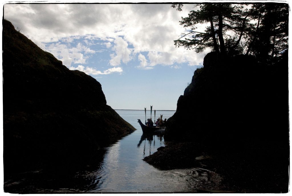 Chinook People's in a canoe coming between some rocks. Picture by Amiran White